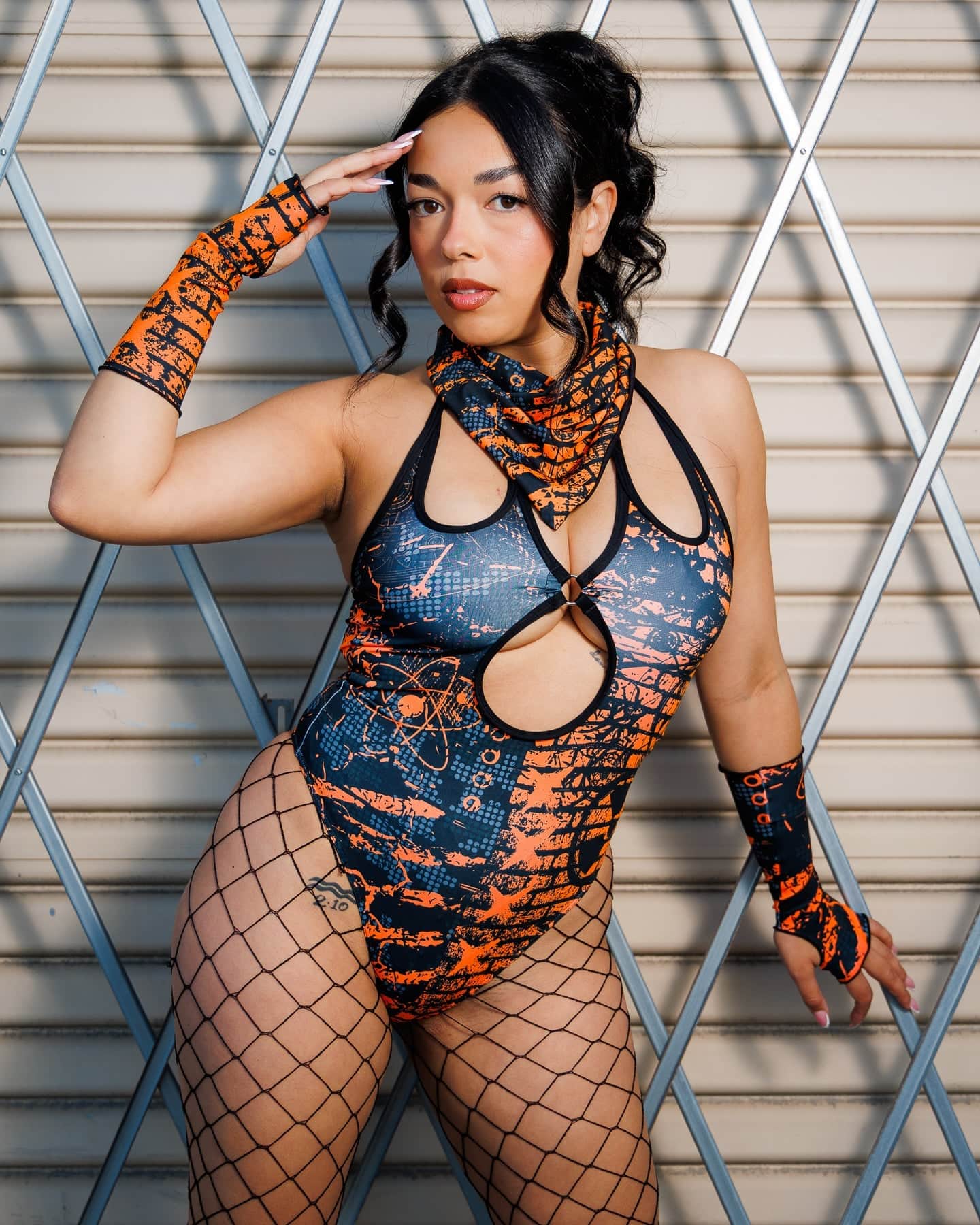 Model wearing the Atomic Bandana in orange and black tones as a face cover, styled with a matching post-apocalyptic outfit.