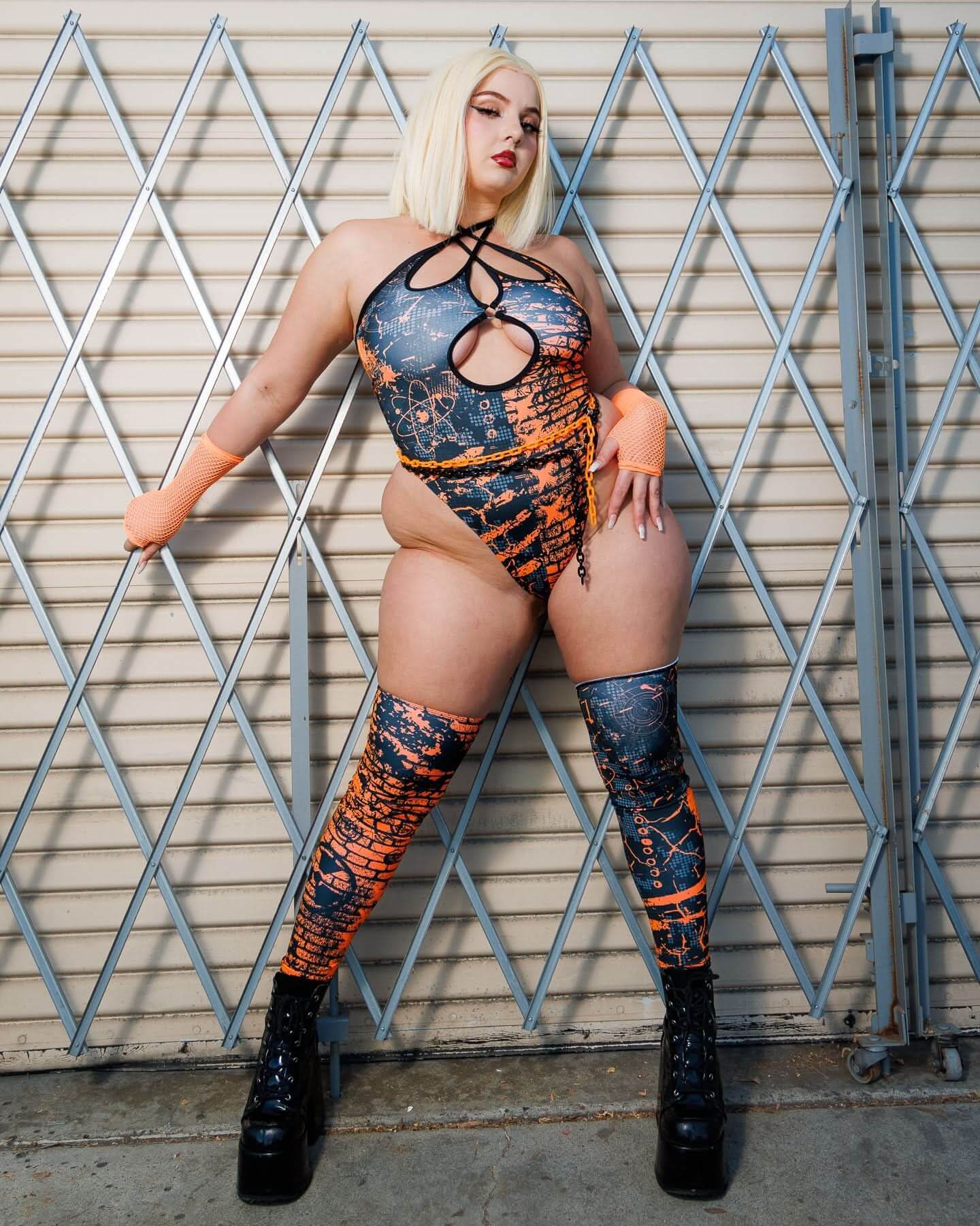 Model wearing the Atomic Cross Faded Bodysuit with black and orange print, showcasing bold fashion in a sleek silhouette.