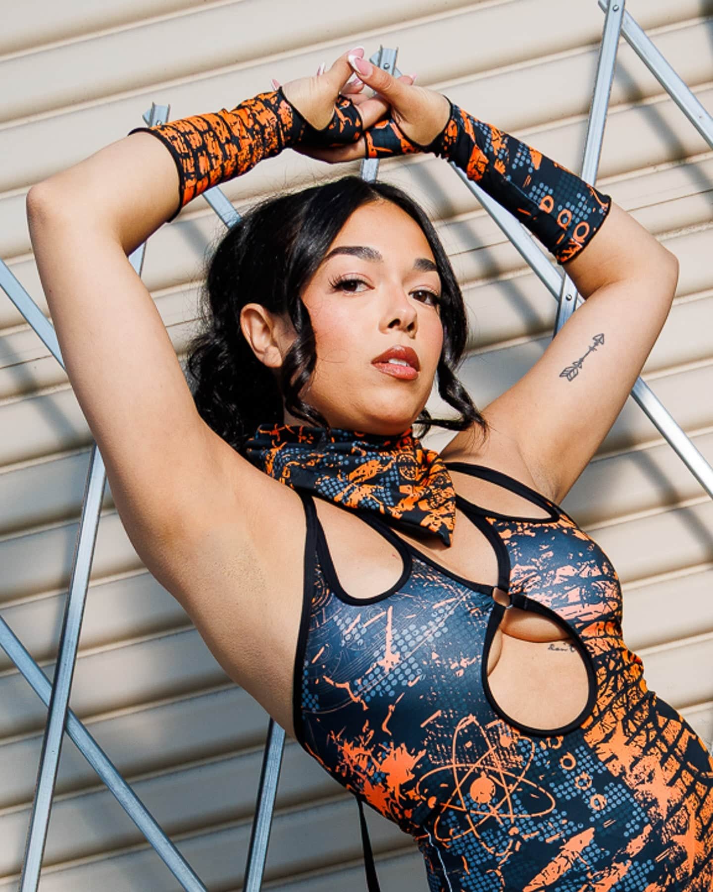 Model wearing Atomic Gloves, featuring flame-meets-galaxy print, in a stylish pose against a geometric background.