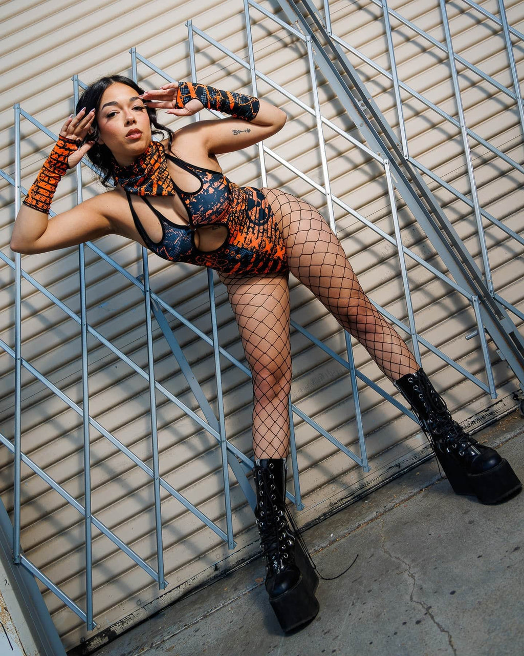 Model wearing Atomic Gloves with flame-galaxy print, posing in edgy attire for a rave-themed fashion look, emphasizing bold style.