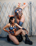 Models wearing Atomic Cross Faded Bodysuits with black and orange print, perfect for festivals or bold fashion statements.