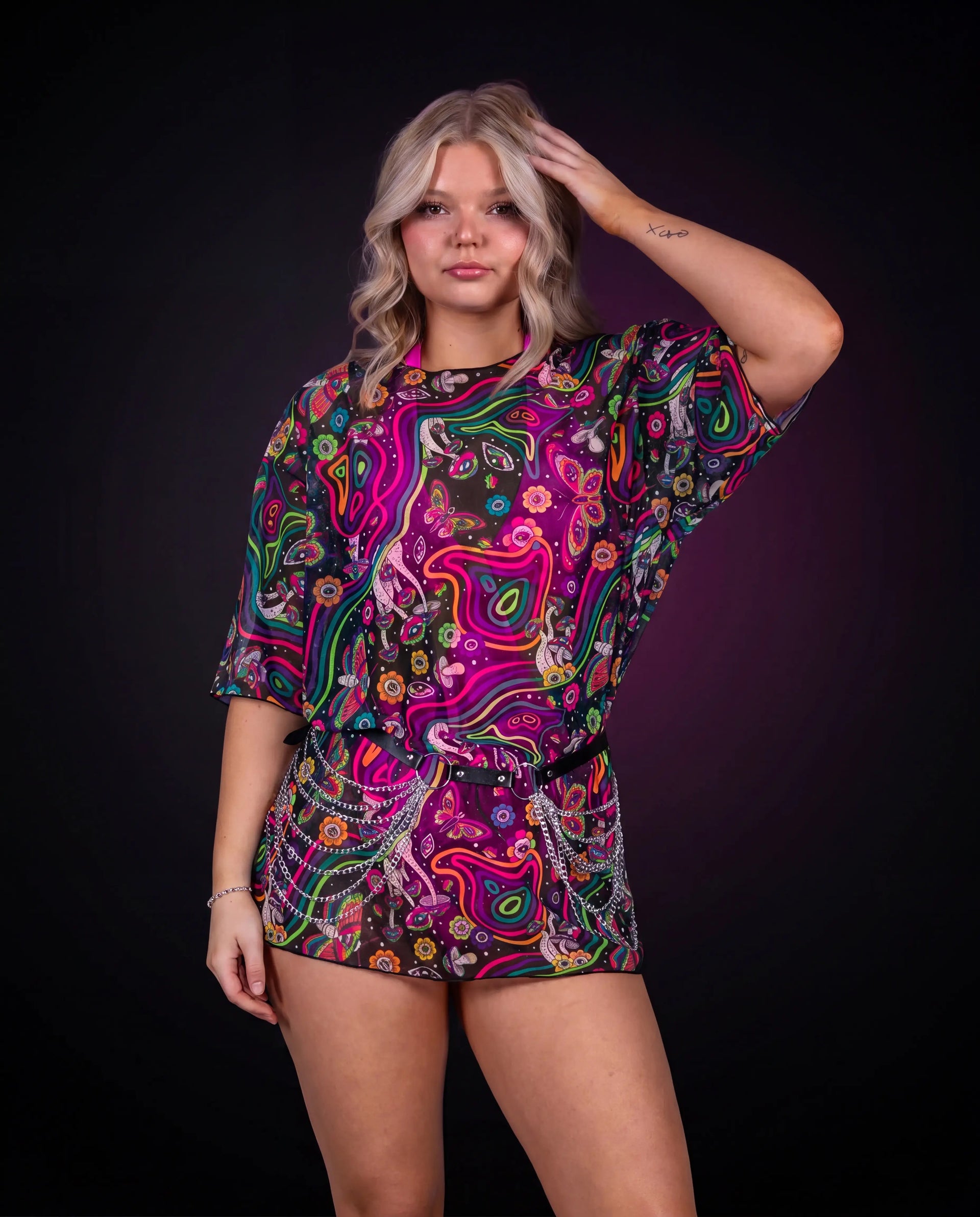 Awaken Mesh Oversized Tee front view, a vibrant psychedelic rave top with a black belt and silver chains. — black