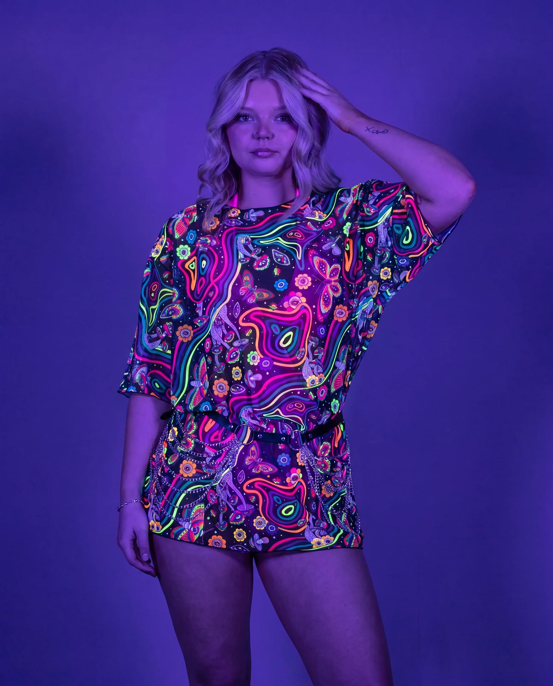 Awaken Mesh Oversized Tee front view, a vibrant psychedelic rave top with a black belt and silver chains. — uv