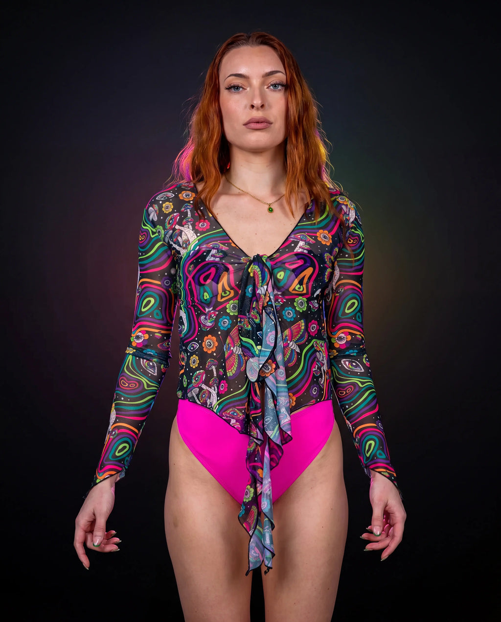 Awaken Sea Fairy Tie Top shown from the front on a model, featuring a sheer, long-sleeved, psychedelic multi-color rave top over a pink bodysuit. — black