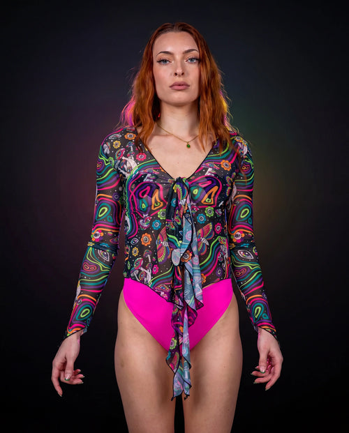 Awaken Sea Fairy Tie Top shown from the front on a model, featuring a sheer, long-sleeved, psychedelic multi-color rave top over a pink bodysuit. — black