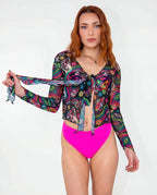 Awaken Sea Fairy Tie Top shown from the front on a model, featuring a sheer, long-sleeved, psychedelic multi-color rave top over a pink bodysuit. — cyc_5