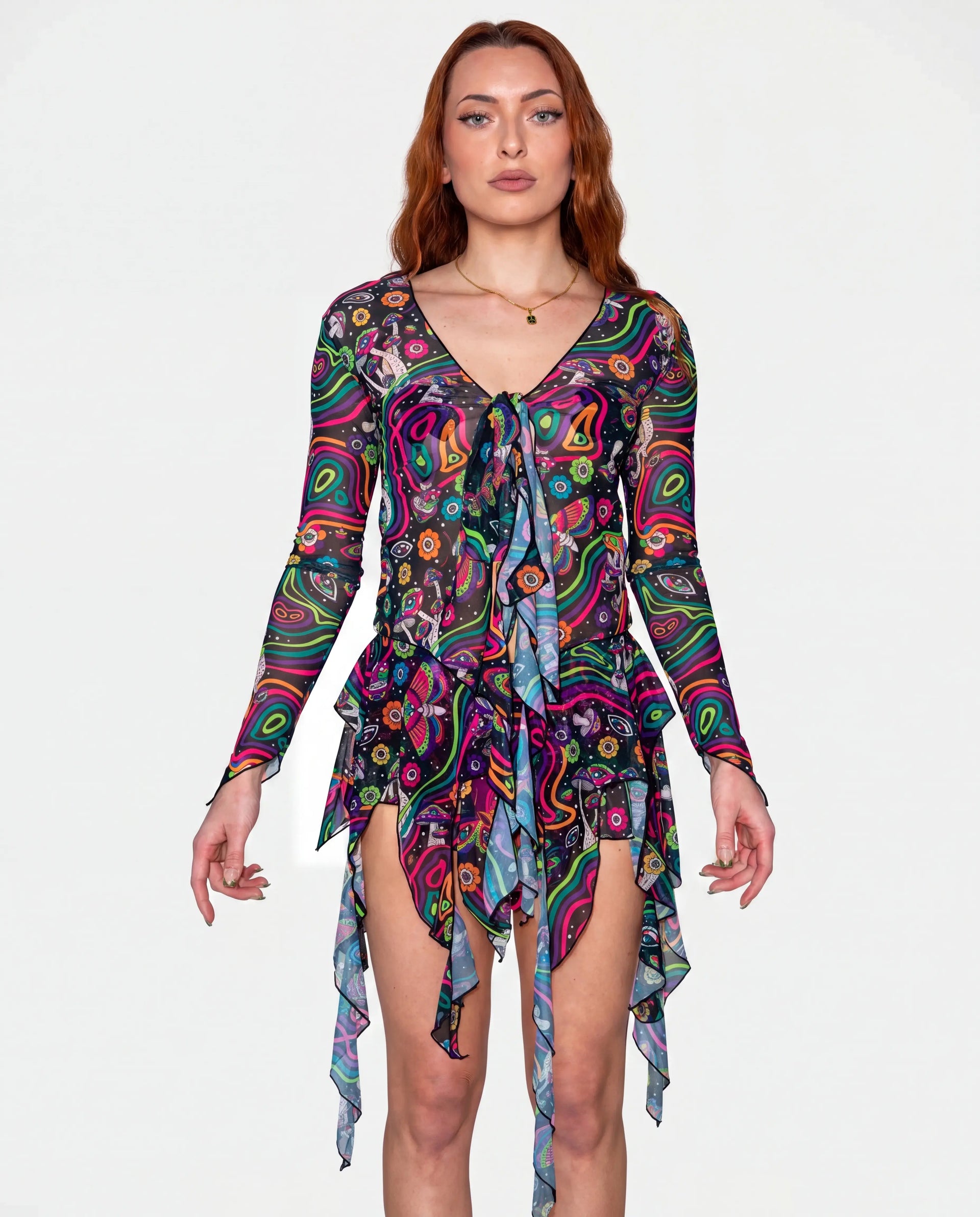 Awaken Sea Fairy Tie Top shown from the front on a model, featuring a sheer, long-sleeved, psychedelic multi-color rave top over a pink bodysuit. — cyc_6