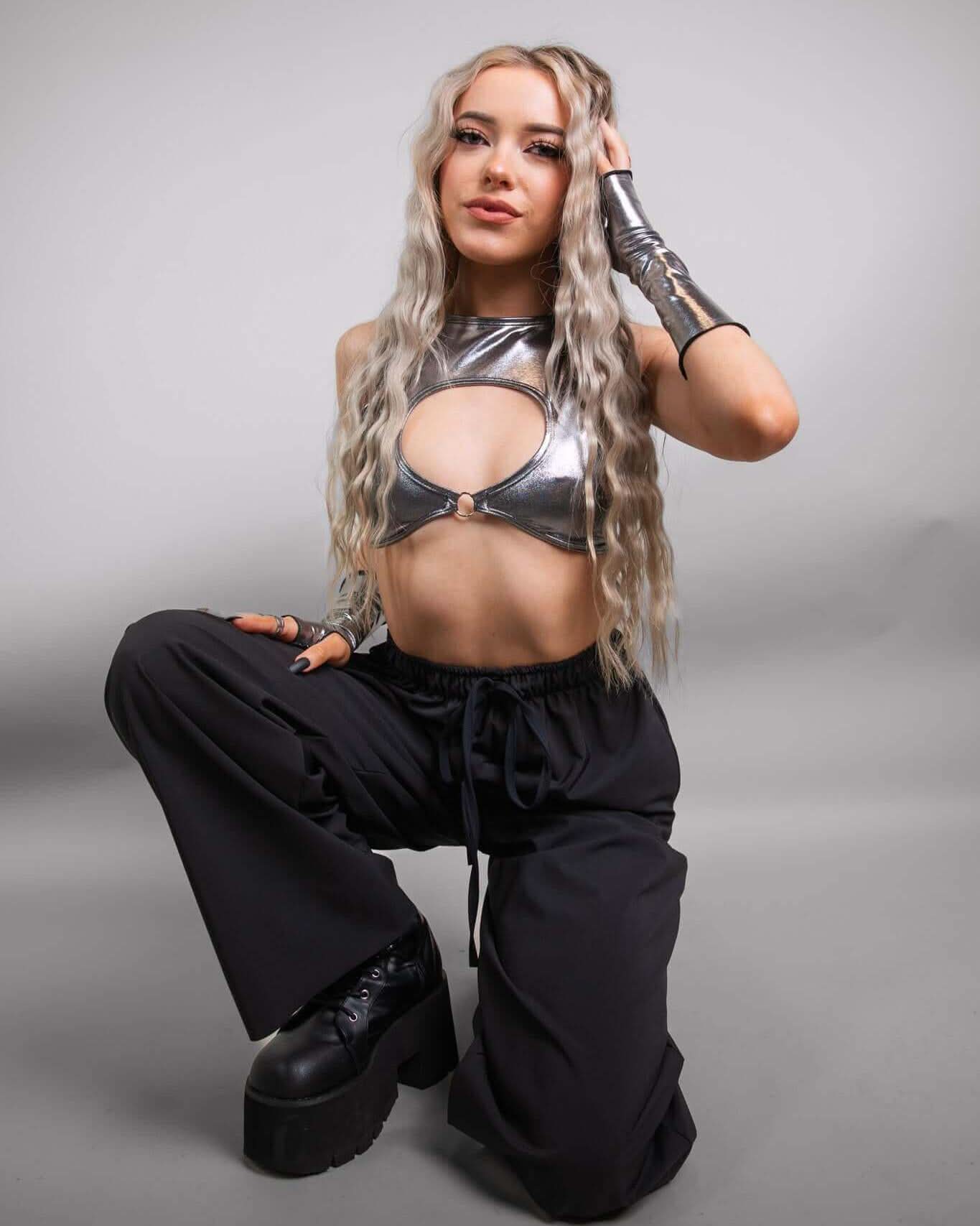 Model wearing Black Lucy Pants and silver crop top, showcasing a stylish rave outfit for dancing all night.