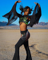 Model showcasing black mesh bell sleeves with rave outfit in a desert landscape, capturing an ethereal vibe.