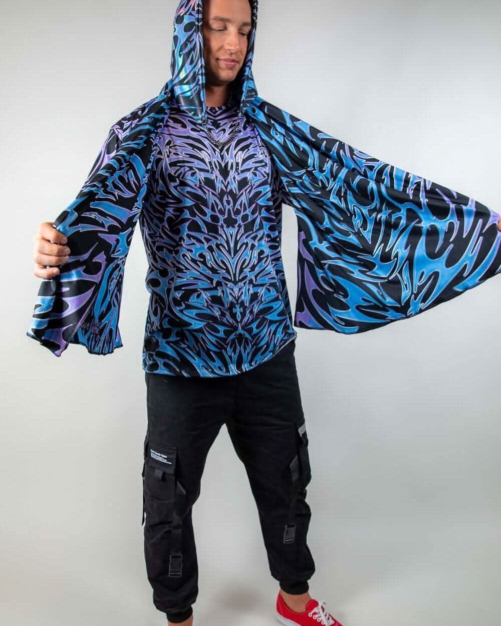 Model wearing the Chromium Festival Scarf with arms spread wide, showcasing its bold cyber sigalism print and hooded design.