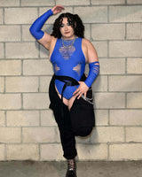 Model wearing a cobalt slit sideboob bodysuit with cutouts, styled for rave outfits against a textured wall.
