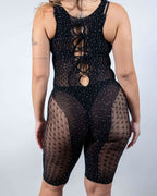 Black rhinestone fishnet rave bodysuit with lace-up chest cutout, festival outfit front view on model