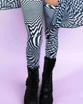 Distortion Leg Sleeves with abstract optical design, paired with black combat boots, perfect for rave outfits.