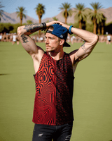 Man wearing Duality Unisex Tank Top in red at a festival among palm trees, showcasing vibrant rave outfit.
