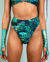 Model wearing Faewood High Waisted Thong with forest print, styled with matching glitter sleeves for a rave-ready look.