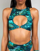 Model wearing Faewood Keyhole Top with O-ring detail, showcasing vibrant forest print, perfect for rave outfits.