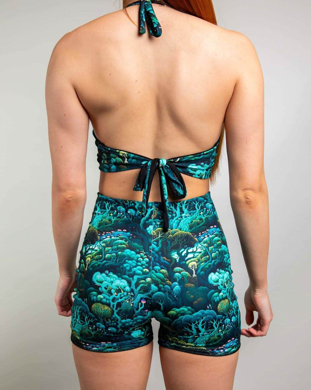 Back view of a woman wearing the Faewood Romper with an enchanted forest design, perfect for rave outfits.