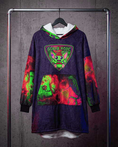 Festival hooded blanket in purple tie-dye with Goblin Mode graphic hanging on rack, rave recovery gear front view