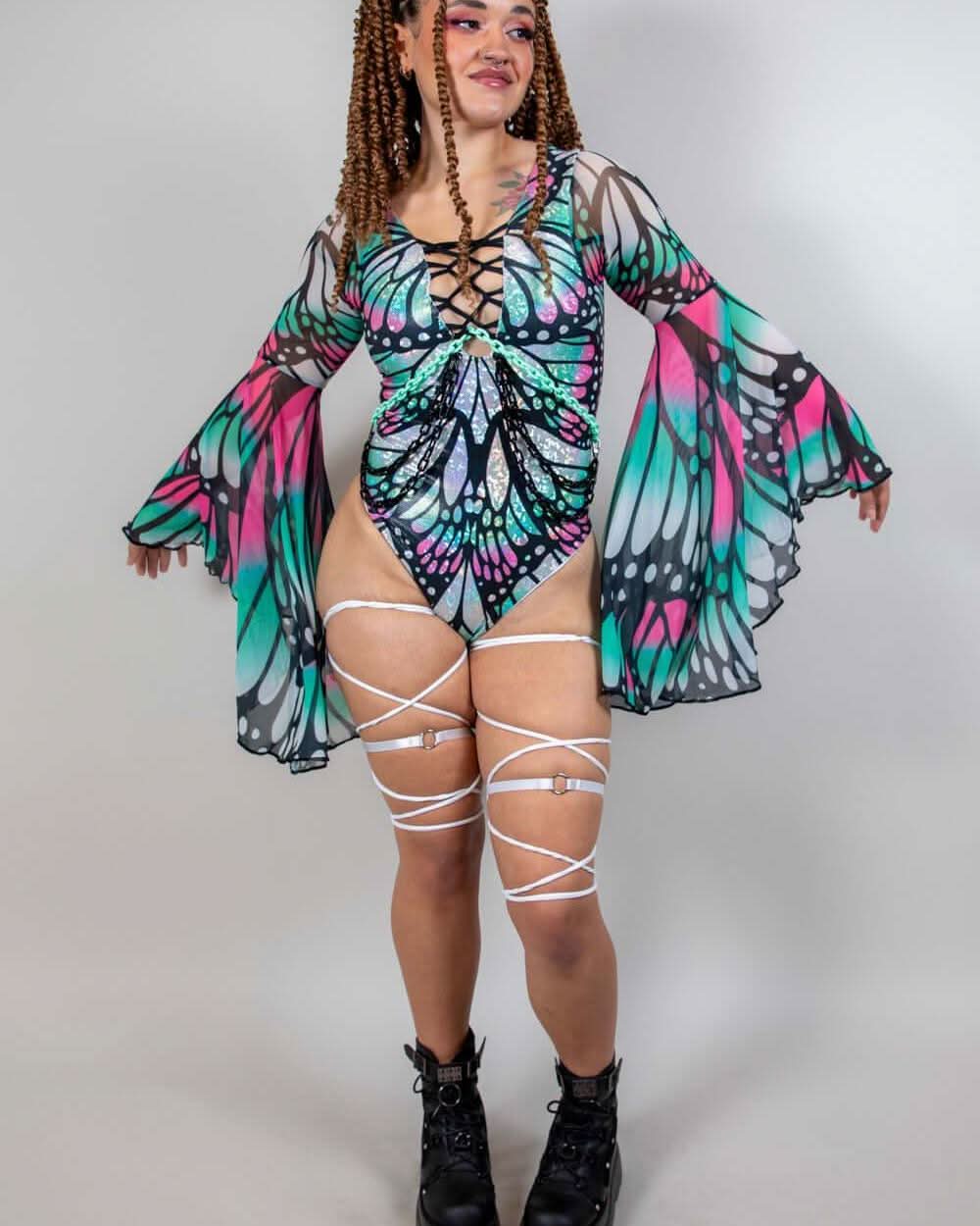 Model in a Flutter Goddess bodysuit with butterfly pattern, lace-up detailing, and flowy bell sleeves, showcasing rave outfits.