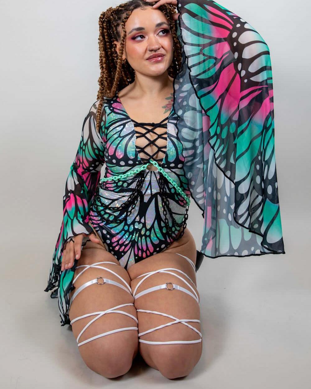 Model showcasing the Flutter Goddess Bodysuit with butterfly pattern, lace-up chest, and flowy sleeves, perfect for rave outfits.