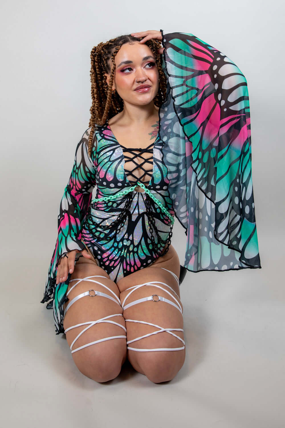 Model showcasing the Flutter Goddess Bodysuit with butterfly pattern, lace-up chest, and flowy sleeves, perfect for rave outfits.