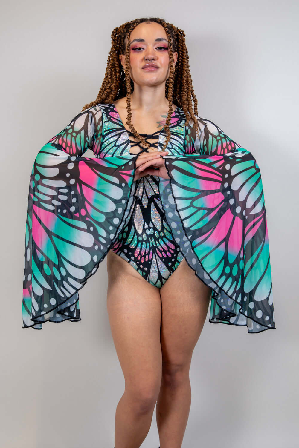 Model showcasing the Flutter Goddess Bodysuit with butterfly pattern and flowy bell sleeves, perfect for rave outfits.