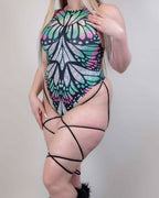 Rave bodysuit with holographic Flutter butterfly print and black leg straps modeled from front angle