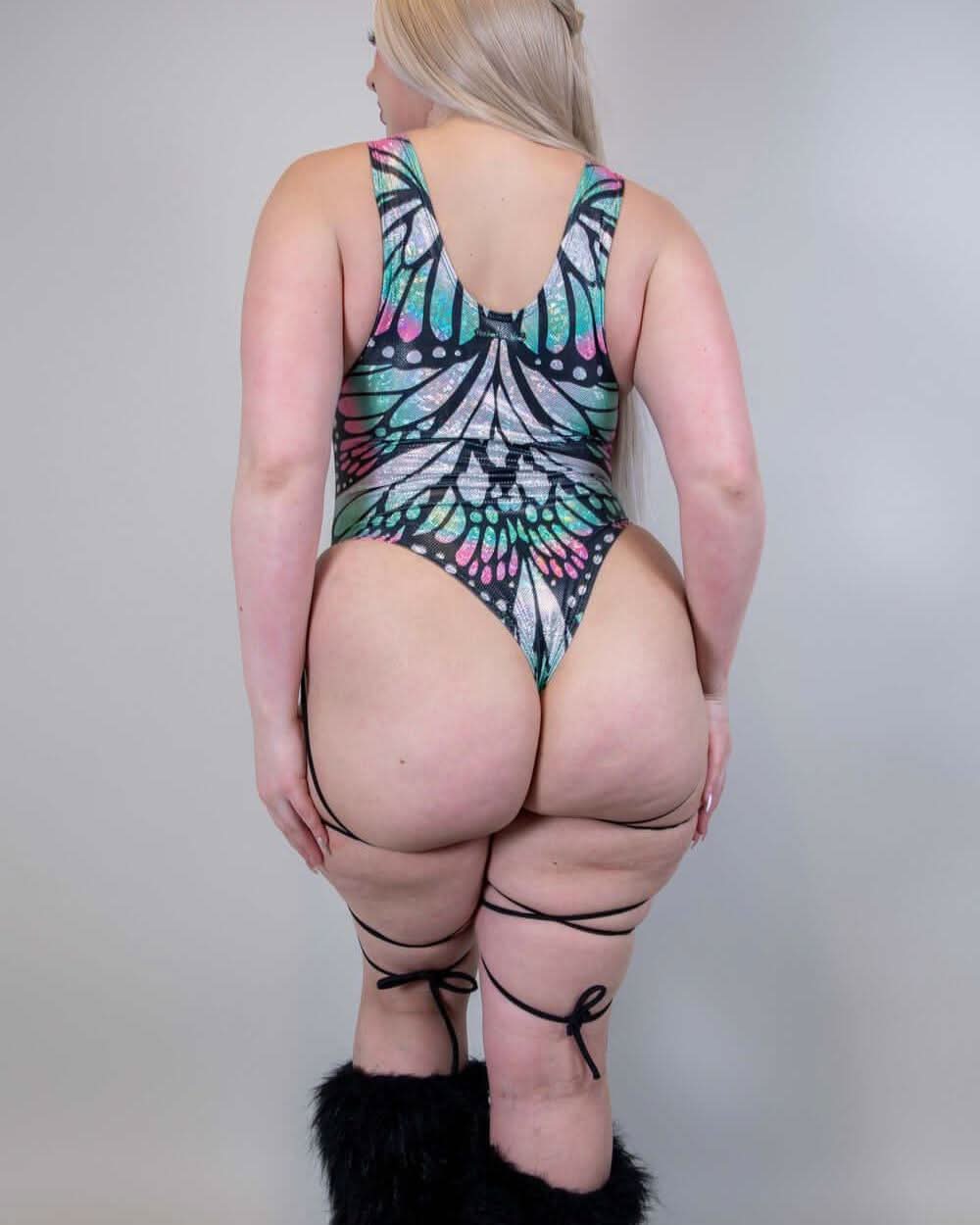 Back view of a woman in a Flutter Sideboob Bodysuit with leg straps and butterfly print, ideal for rave outfits.