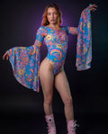 Groovy Goddess Bodysuit front view, featuring a model in a vibrant psychedelic rave bodysuit with bell sleeves and lace-up detail.
