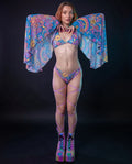 Groovy Mesh Bell Sleeves on a model from the front, showcasing the vibrant psychedelic pattern with suns, peace signs, and rainbows, perfect for a rave festival.