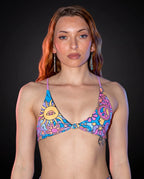 Groovy Serendipity Top front view, showcasing the pastel rave bikini top with peace signs, daisies, and a third-eye sun.