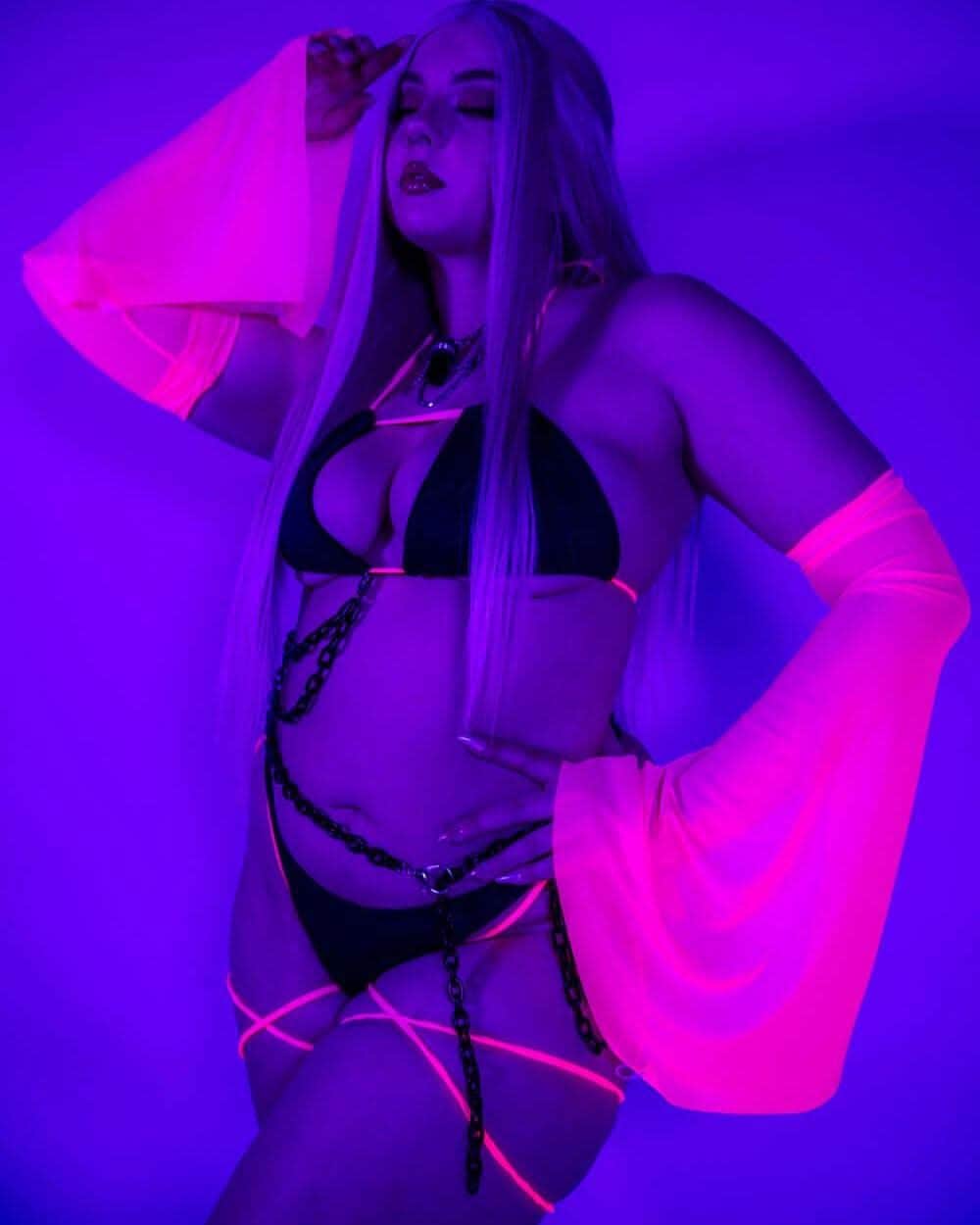 Neon-lit shot of the Hot Pink Metamorphosis Arm Sleeves, glowing under blacklight for a bold rave-ready effect.