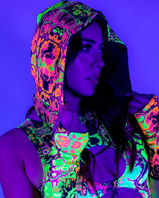 Model wearing Intensity Assassin Hood with vibrant UV print, showcasing stylish rave outfits under neon lighting.