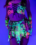 Model wearing a vibrant neon Intensity Fairy Skirt and matching top, perfect for rave outfits in blacklight.
