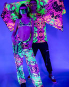 Vibrant couple in neon rave outfits showcasing the Intensity Festival Scarf under UV light.