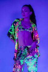 Model showcasing vibrant neon rave outfit featuring skull patterns, perfect for festivals and night events.