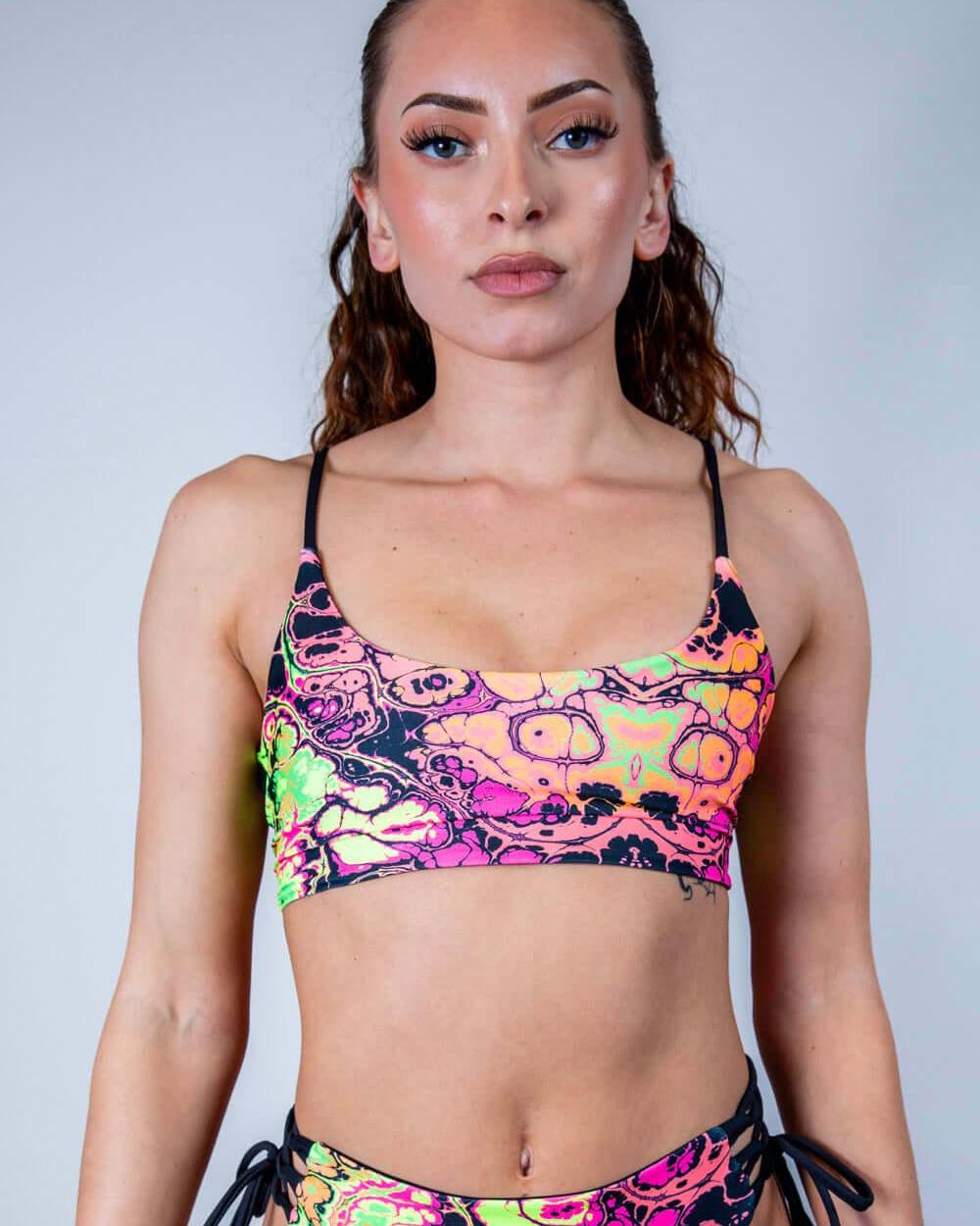 Model wearing Intensity Reversible Lush Top in vibrant UV reactive colors, perfect for rave outfits and stylish looks.