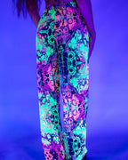 Rave bodysuit style Intensity Mesh Lucy pants glowing in neon colors under blacklight at festival