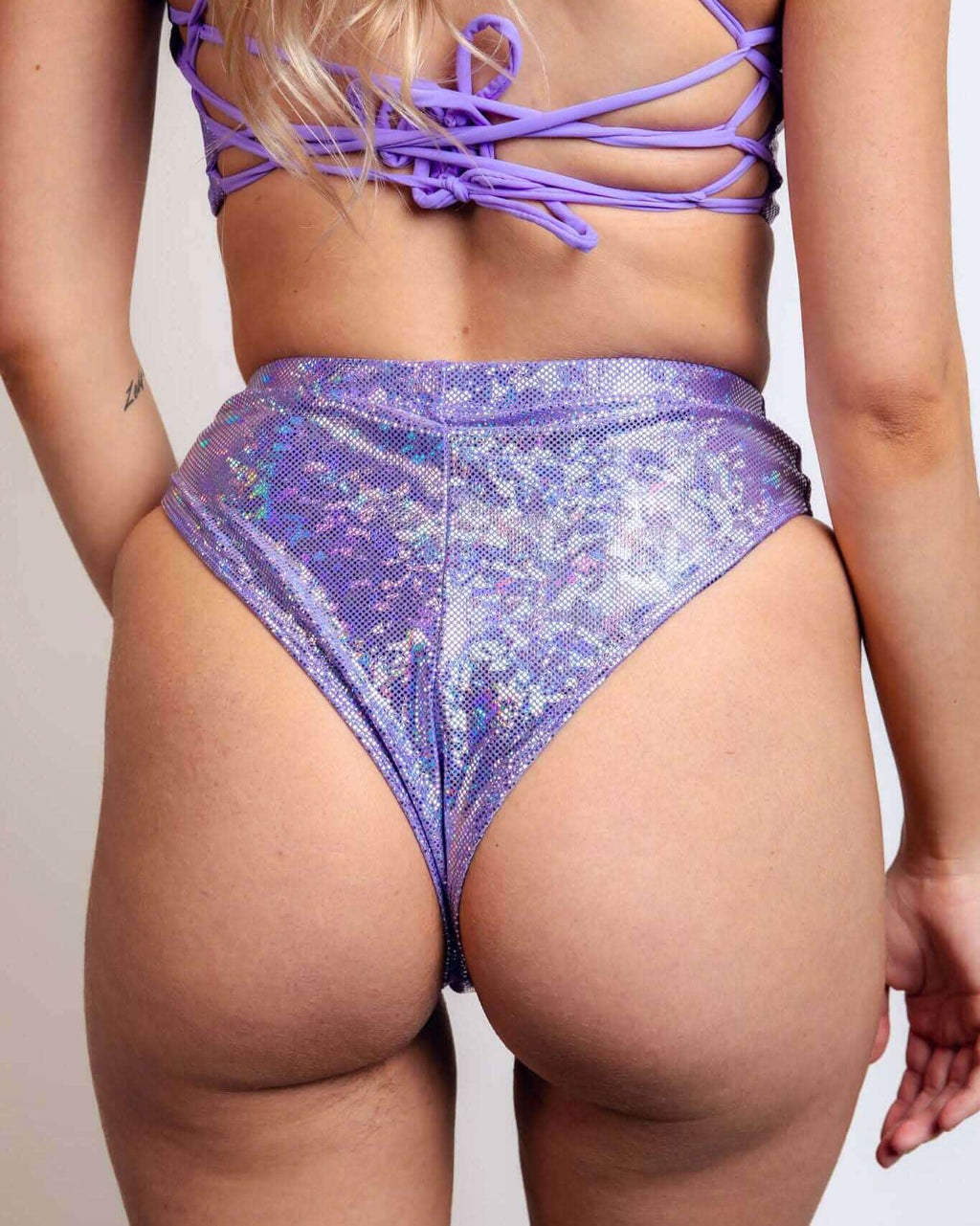 Shimmering lavender high-waisted Brazilian bottoms, perfect for rave outfits, showcasing a cheeky back design.