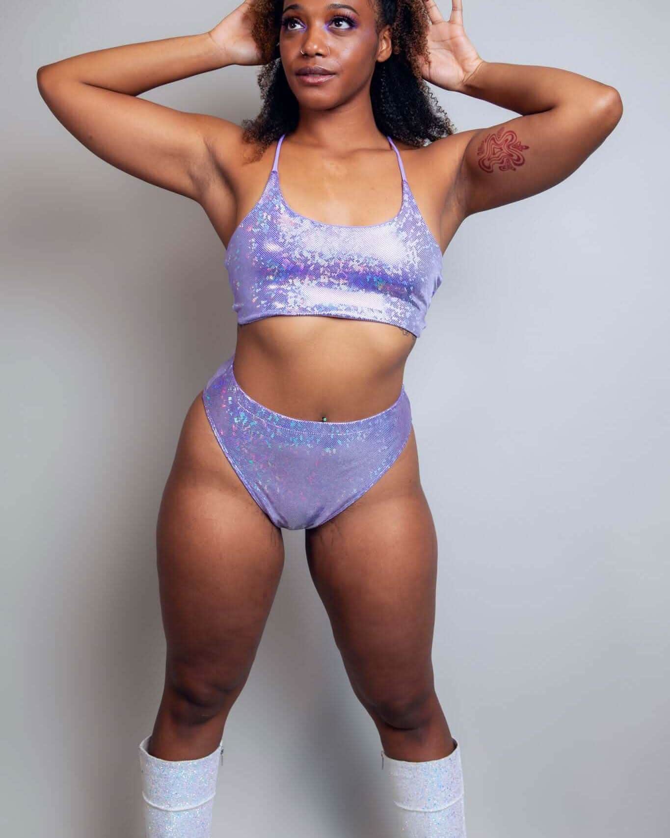 Model wearing shimmering lavender high-waisted Brazilian bottoms and crop top, perfect for rave outfits.
