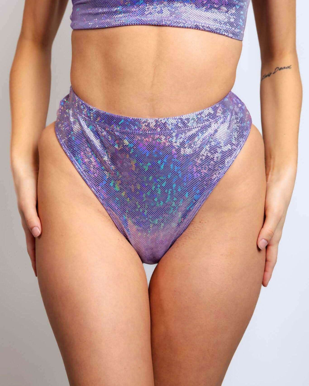 High-waisted lavender holographic Brazilian bottoms, perfect for rave outfits and stylish night outs.