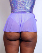 Back view of lavender mesh swirl rave skirt with wrap tie detail and holographic festival top