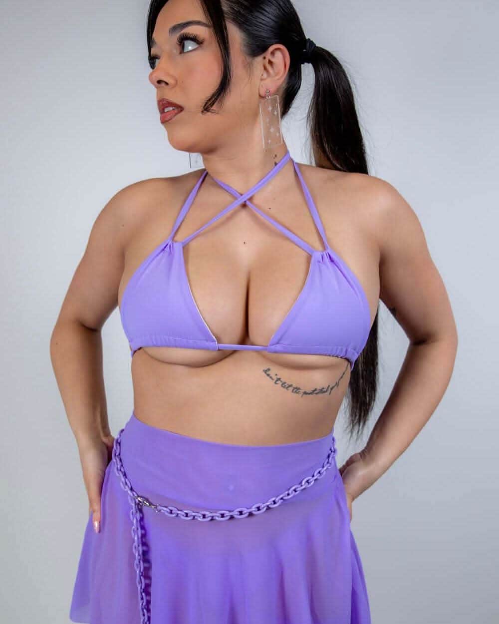 Model wearing lavender strappy rave top with geometric cross-strap design, festival outfit front view