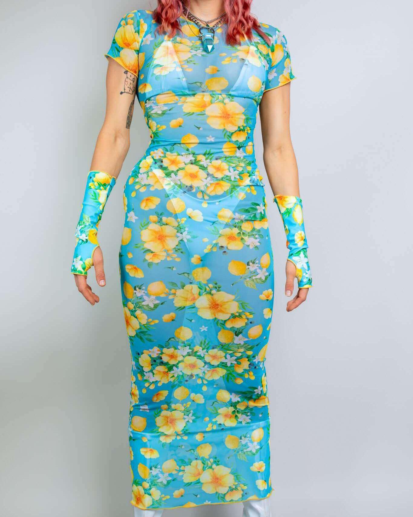 Model wearing a Lemon Drop Mesh Baby Tee Maxi Dress with bright floral print, perfect for rave outfits and summer events.