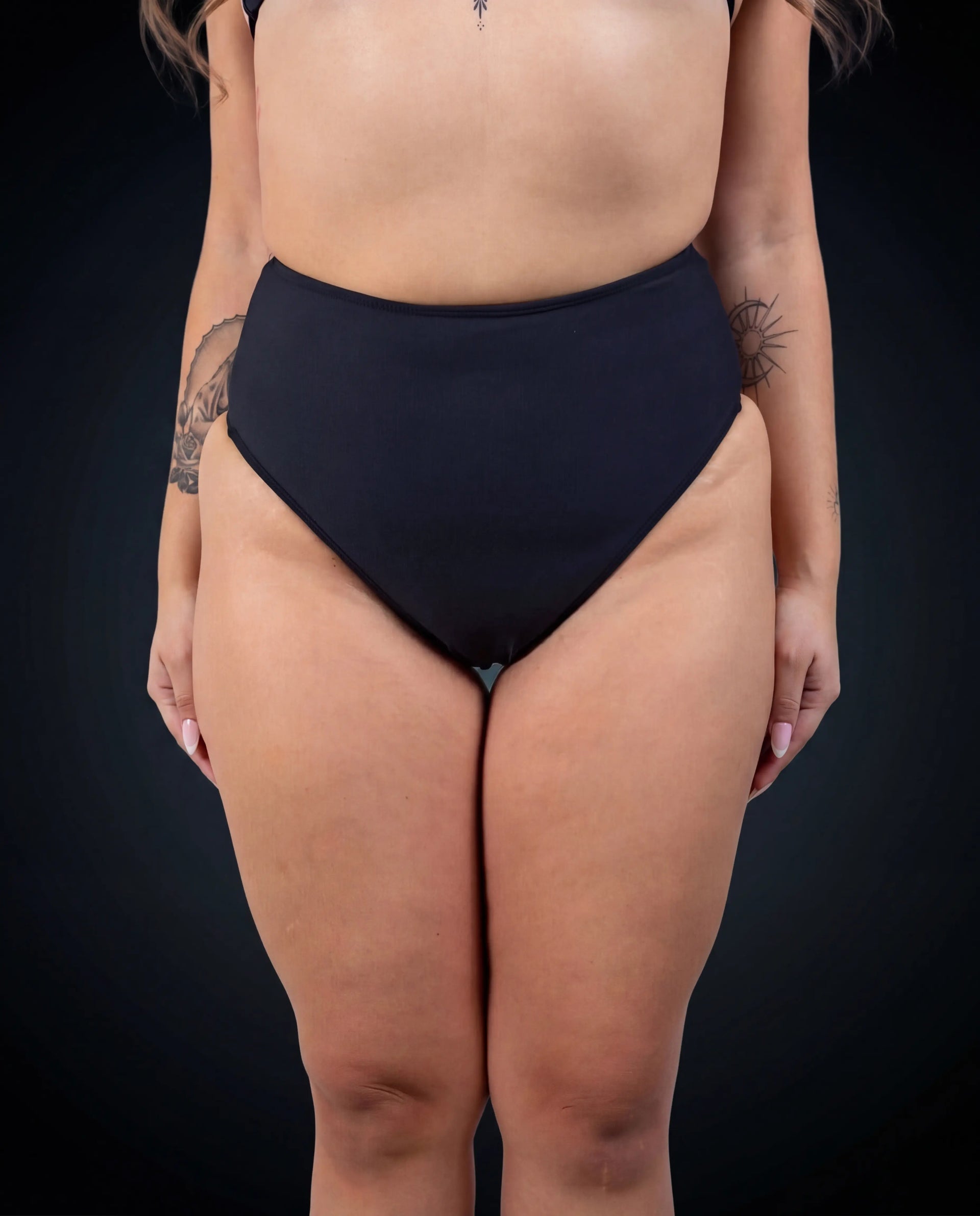 Matte black high waisted rave pants bikini bottoms front view festival outfit modeling shot