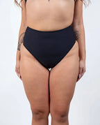 Matte black high waisted rave pants bikini bottoms front view festival outfit modeling shot