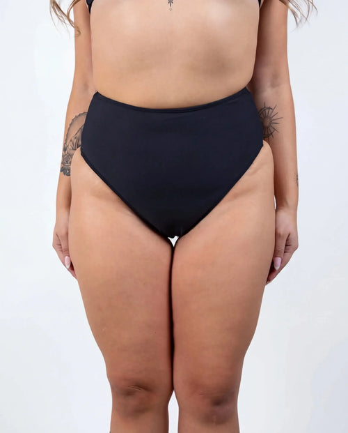 Matte black high waisted rave pants bikini bottoms front view festival outfit modeling shot