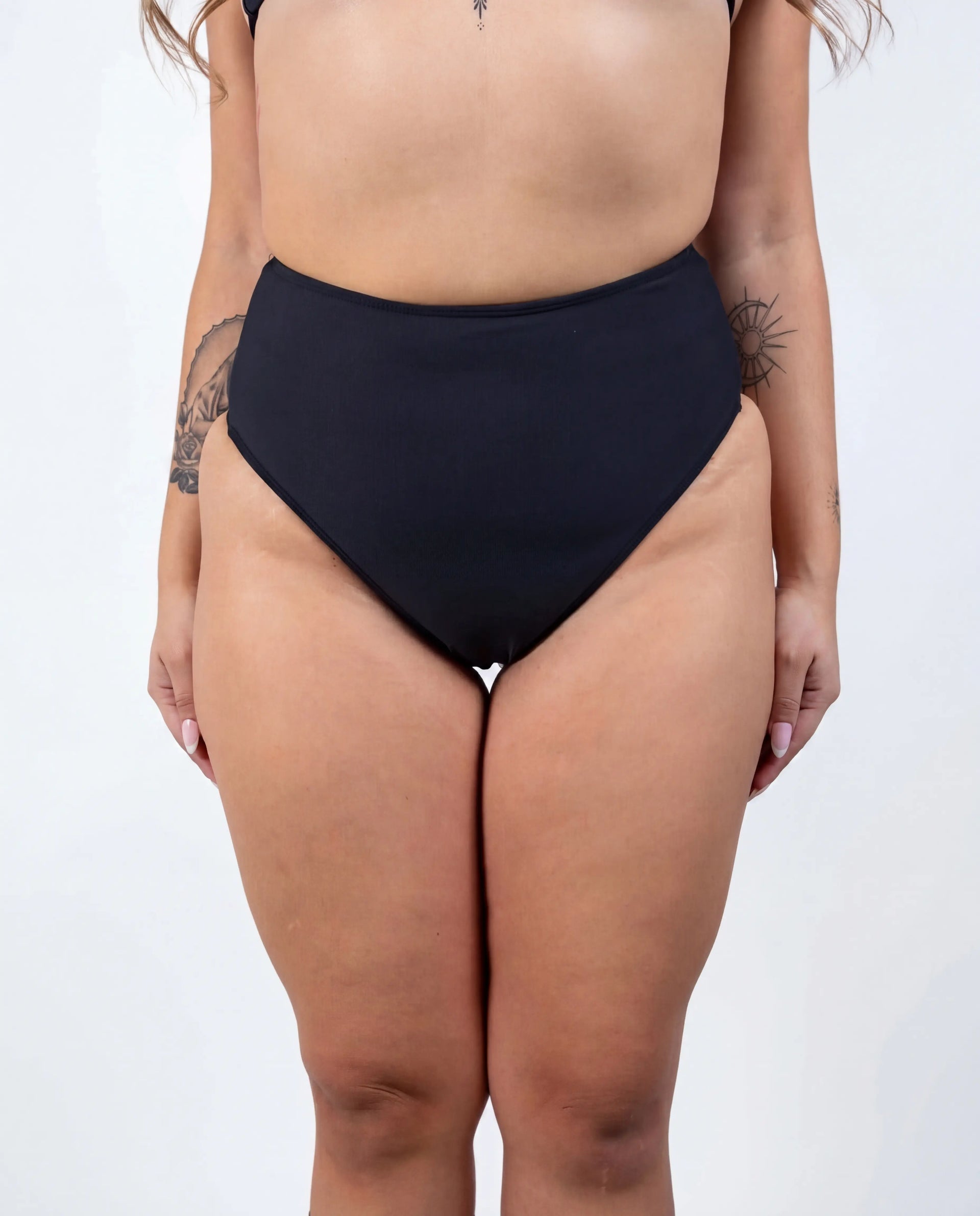 Matte black high waisted rave pants bikini bottoms front view festival outfit modeling shot — white
