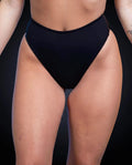 Matte black high waisted thong rave pants modeled from front view for festival outfit styling