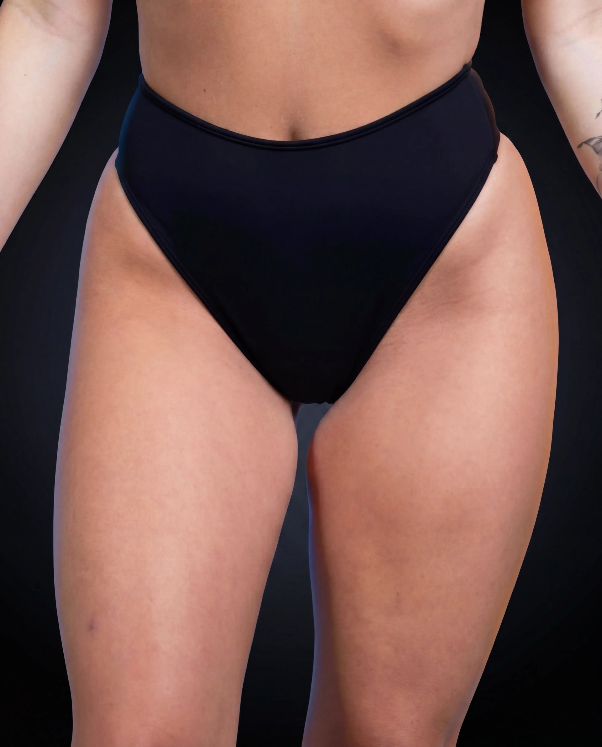 Matte black high waisted thong rave pants modeled from front view for festival outfit styling